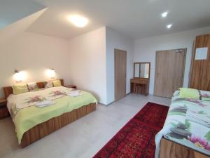 a bedroom with two beds and a red rug at Hotel Vyšehrad in Turčianske Teplice