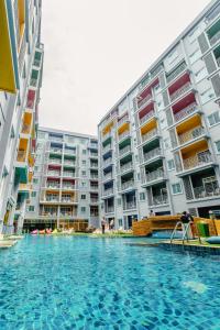 a swimming pool in front of some apartment buildings at Bauman Residence Patong, Phuket in Patong Beach
