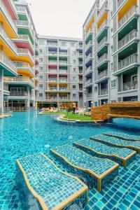 - une piscine avec chaises longues devant les appartements dans l'établissement Bauman Residence Patong, Phuket, à Patong Beach