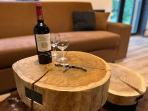 butelka wina na drewnianym stole z kieliszkiem wina w obiekcie Apartmán Herlíkovice 303 w Vrchlabi