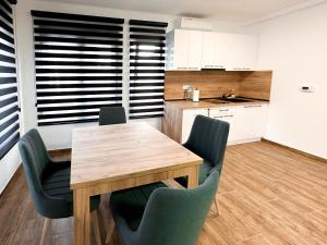 a kitchen with a wooden table and chairs at Kiko apartmani LUX in Zrenjanin