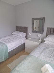 a bedroom with two beds and a mirror on the wall at The Haven in Beadnell