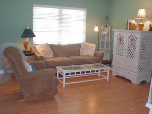 een woonkamer met een bank en een salontafel bij Palm Cottage #54605 in Holmes Beach