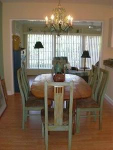 een eetkamer met een tafel met stoelen en een kroonluchter bij Palm Cottage #54605 in Holmes Beach