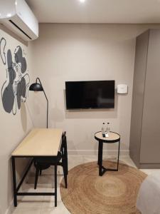 a room with a table and a tv on a wall at Studio apartment at Blackbrick 2 in Johannesburg