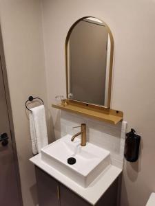 uma casa de banho branca com um lavatório e um espelho em Studio apartment at Blackbrick 2 em Joanesburgo