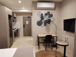 a living room with a table and a kitchen at Studio apartment at Blackbrick 2 in Johannesburg
