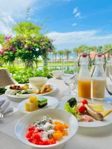 una mesa con platos de comida y botellas de zumo en Villa sân vườn Misa, en Phan Thiet