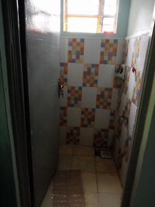 a bathroom with a shower with a tiled floor at Black gate in Nanyuki