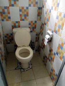 a bathroom with a toilet in a room with colorful tiles at Black gate in Nanyuki