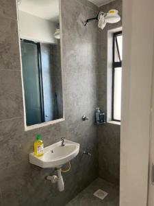 a bathroom with a sink and a mirror at Pazoori Furnished Studios and 1 bedrooms in Nairobi