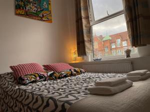łóżko z ręcznikami w pokoju z oknem w obiekcie Spacious Family Flat w Londynie