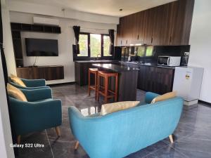 a kitchen with a blue couch and chairs in a room at BULA VIP LOUNGE in Suva