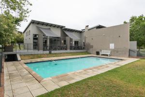 a swimming pool in front of a house at Dainfern K Luxe Apartment in Sandton