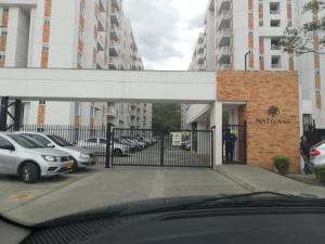 a parking lot with cars parked in front of a gate at Apartamento Nativa Tropical in Villeta +2 photos