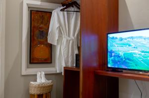 a room with a television and a white shirt hanging on a wall at Reservoir Hotels in Siem Reap