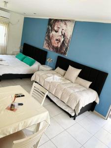 恰哈里的住宿－DINASTIE APART HOTEL，一间卧室设有两张床,墙上挂着一幅画