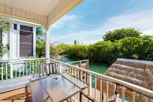 ein Balkon mit Tisch und Blick aufs Wasser in der Unterkunft Coral Queen Palm in Key West