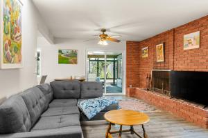 a living room with a couch and a brick wall at Gold Coast Getaway in Santa Barbara