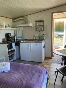 a kitchen with white appliances and a table in a room at Fjordutsikten Motell & Camping AS in Lakselv