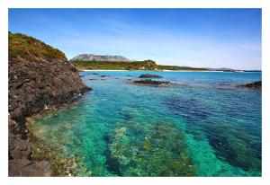 vistas a una playa con agua azul y rocas en Kianna Bed&Breakfast, en Dorgali