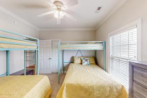 a bedroom with two bunk beds and a ceiling fan at A Shore Pleasure in Myrtle Beach