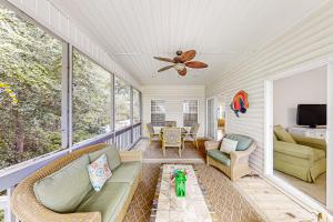 a screened in porch with a couch and a ceiling fan at A Shore Pleasure in Myrtle Beach