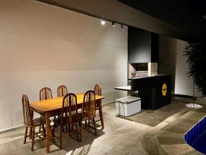 uma sala de jantar com mesa e cadeiras e um piano em Acomodações do Tio Will - 2 no Guarujá