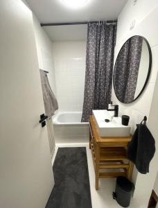 ein Badezimmer mit einem Waschbecken, einer Badewanne und einem Spiegel in der Unterkunft Panorama-Perle mit 101 m² im Herzen von Köln in Köln