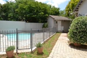 a fence in front of a swimming pool at Lonehill - Suite 1 in Sandton