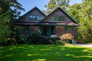 una casa con un césped verde delante de ella en Cedar Crest Retreat en Southampton