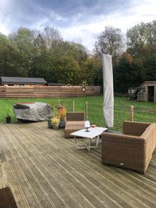 a patio with two wicker chairs and a table at A l'orée du bois "maison de vacances" in Spa