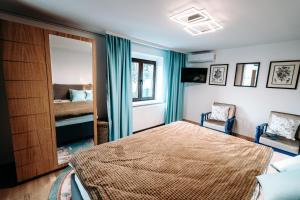 Schlafzimmer mit einem Bett und einem Spiegel in der Unterkunft The Cypress Villa & Vineyard II in Sremska Kamenica