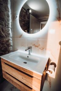 ein Bad mit einem Waschbecken und einem Spiegel in der Unterkunft The Cypress Villa & Vineyard II in Sremska Kamenica