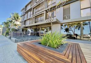 a building with a wooden bench in front of it at UNITY Cabo Branco by PenareiaTurBr in João Pessoa +9 photos