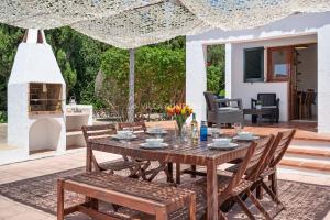 a wooden table and chairs on a patio at Villa BINIKIXA in Binibeca