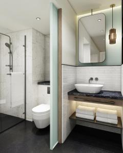 a bathroom with a sink and a toilet and a mirror at The Halyard Liverpool, Vignette Collection, an IHG Hotel in Liverpool