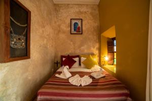 um quarto com uma cama com sapatos em Riad Le Jardin de Lea, Suites & Spa em Marraquexe