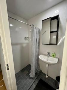 a white bathroom with a sink and a shower at Savi Apartment 5 in Pärnu