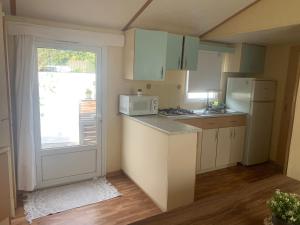 cocina con electrodomésticos blancos y puerta con ventana en Nice little house, en Barcelona