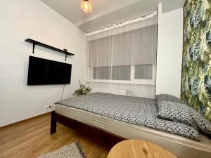 a bedroom with a bed and a flat screen tv at Savi Apartment 5 in Pärnu +3 photos