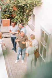 a group of people standing outside a building eating food at Weinforum Franken Hotel & Restaurant in Eibelstadt