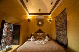 a bedroom with a bed with two dolls on it at Riad Le Jardin de Lea, Suites & Spa in Marrakesh