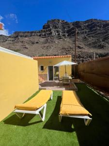 two beds on a lawn with a mountain in the background at SUNNY CARMELITO DELUXE in Mogán