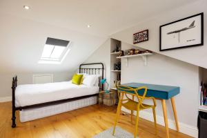 a bedroom with a bed and a blue desk at Veeve - Soulful Smiles in London