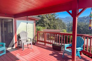a porch with two chairs and a view of the mountains at The Sand Dollar House in Carpenterville