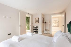 a white bedroom with a large bed with white pillows at Aire Apartments (Central) - Executive City Center Apartments in Leeds