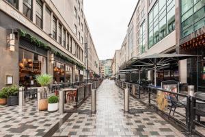 Une rue vide avec des tables et des chaises dans une ville dans l'établissement Aire Apartments (Central) - Executive City Center Apartments, à Leeds
