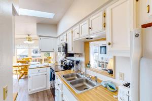 a kitchen with white cabinets and a sink at The Sand Dollar House in Carpenterville