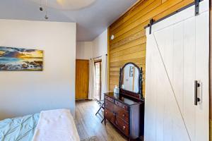 a bedroom with a mirror and a dresser and a door at The Sand Dollar House in Carpenterville